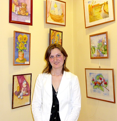 Валерия Васильева, преподаватель детской студии искусств Долининой на фоне работ своих учеников