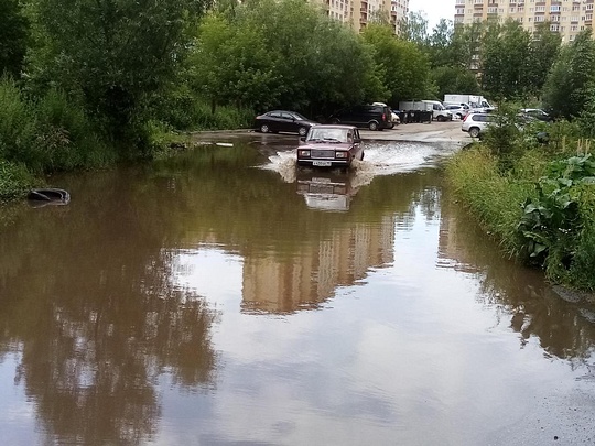 Машина преодолевает проблемный участок, После дождей в Звенигороде затапливает придомовую территорию