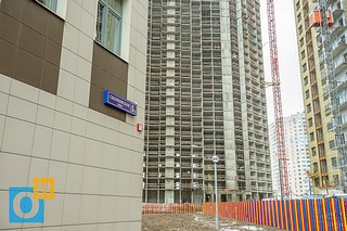 Здание школы с трёх сторон окружено бетонной стеной 25-ти этажных жилых домов
