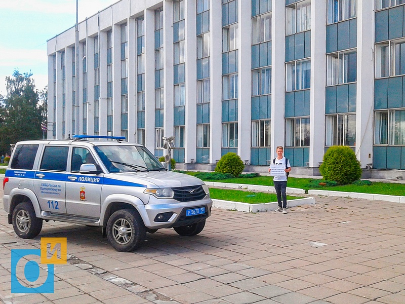 Полицейская машина и участник пикета у администрации, В Одинцово задержали активистов, которые агитировали за благоприятную окружающую среду