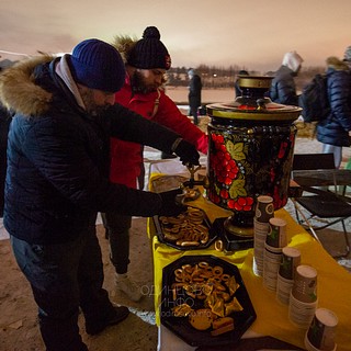 Участники купаний наливают чай из самовара