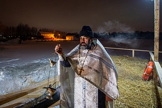 Священнослужитель освящает место купания