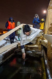 Священнослужитель освящает место купания