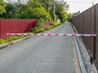 Основание шлагбаума установлено на примыкающем к проезжей части земельном участке и замаскировано плоскостями забора