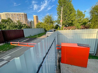 Механизм дистанционно управляемого шлагбаума установлен на примыкающей к проезжей части земельном участке и замаскирован плоскостями забора, 1-я Советская улица, Одинцово