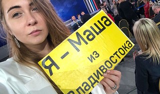 Журналистка с плакатом на пресс-конфенции