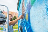 Дмитрий Лёвочкин наносит рисунок на стену трансформаторной