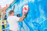 Дмитрий Лёвочкин наносит рисунок на стену трансформаторной