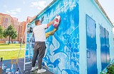 Дмитрий Лёвочкин наносит рисунок на стену трансформаторной
